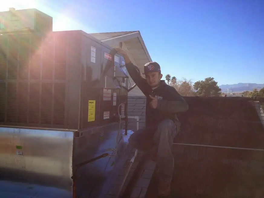 HVAC technician performing Air Duct Repair on a rooftop unit in Boulder